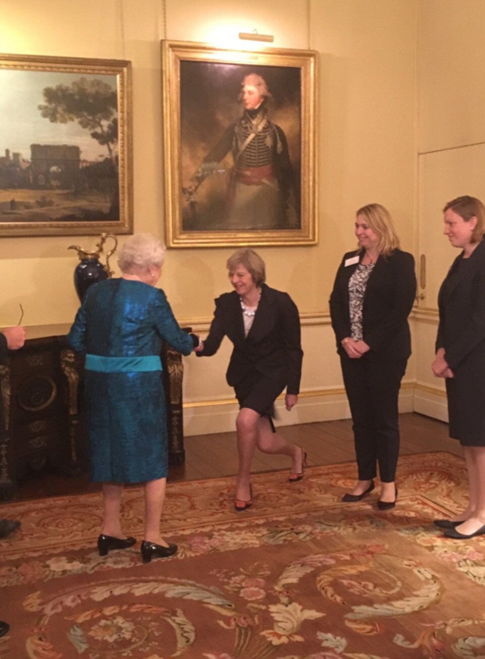 Theresa May Kneels To Greet Members Of The Royal Family